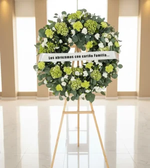 Corona para difunto con eucaliptos y hortensias verdes — una composición floral sobria y elegante que combina la fragancia fresca y relajante de los eucaliptos con la serenidad